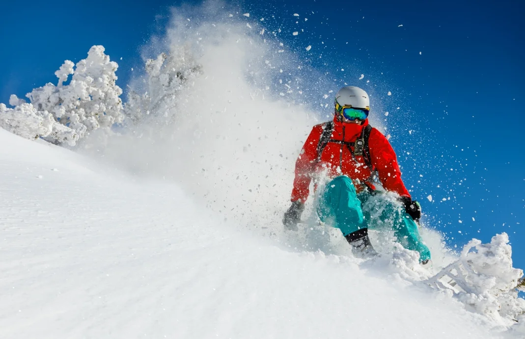 man skiing down a snowy mountain